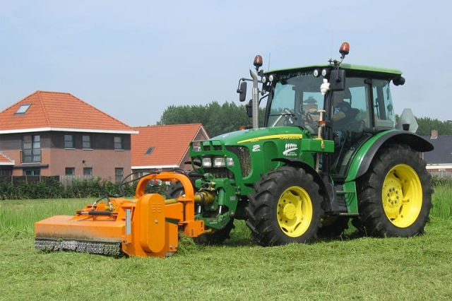 Осенний покос травы трактором на корм и для ухода за полями и пастбищами